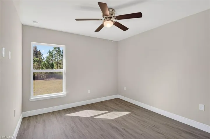 Empty room with wood finished floors and ceiling fan
