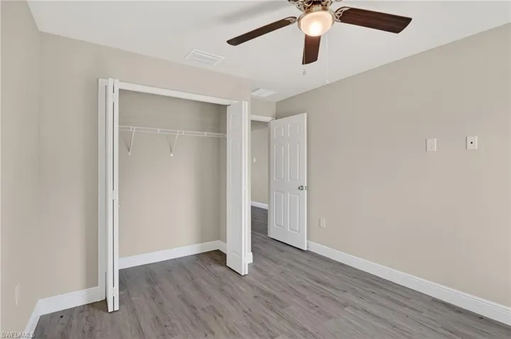 Unfurnished bedroom with light wood-style floors, a closet, and a ceiling fan