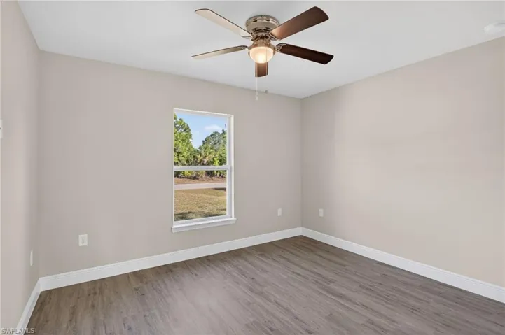 Empty room with wood finished floors and ceiling fan