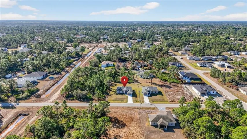 Aerial view of property's location with nearby suburban area