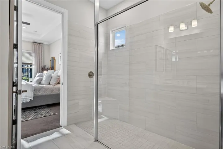 Ensuite bathroom with healthy amount of natural light and a stall shower