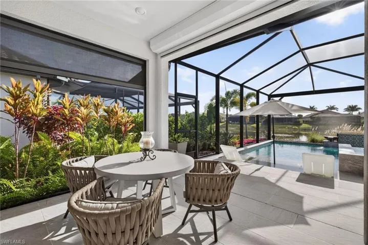 View of patio featuring a lanai, a sunroom, an outdoor pool, and outdoor dining space