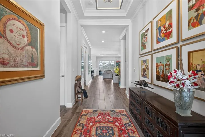 Hall featuring dark wood-style floors and ornamental molding