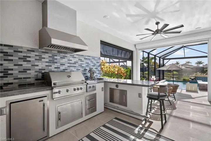 View of patio / terrace featuring a sunroom, a ceiling fan, a lanai, an outdoor pool, and area for grilling