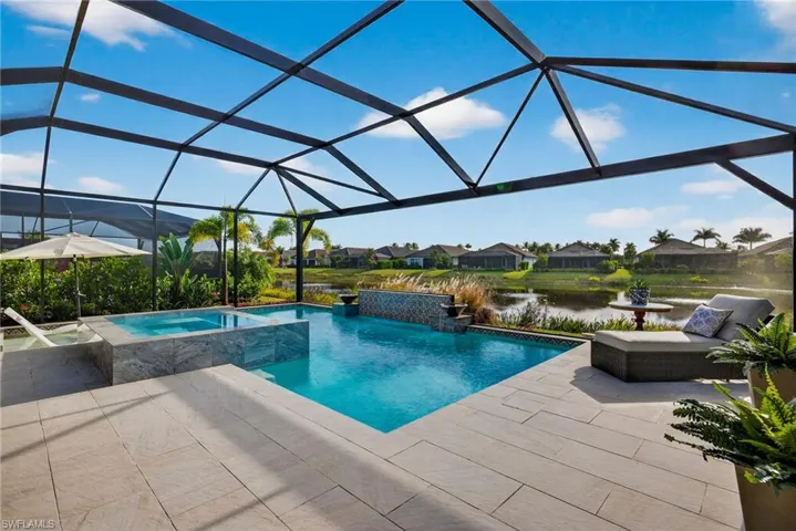 View of pool with a residential view, glass enclosure, a sunroom, a pool with connected hot tub, and a patio