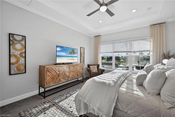 Bedroom with carpet, a ceiling fan, a raised ceiling, and recessed lighting