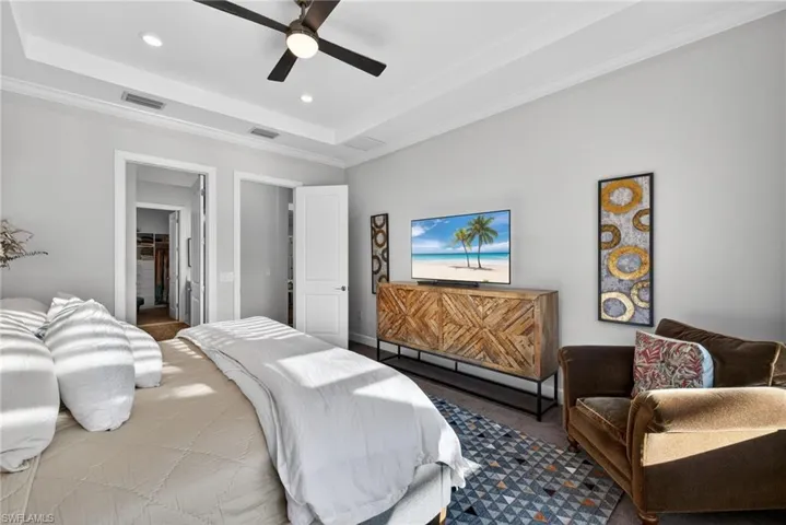 Bedroom with ornamental molding, ceiling fan, recessed lighting, a raised ceiling, and carpet