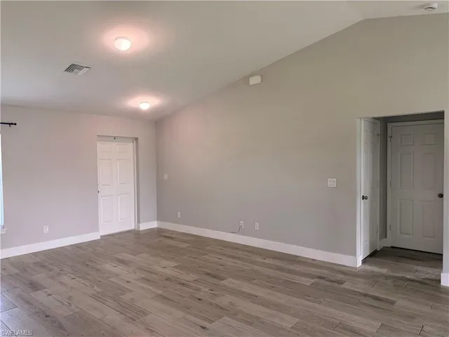 Vaulted ceiling with recessed lighting, complemented by light grey walls and white baseboards