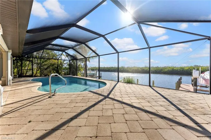 Pool with a patio, a water view, and a lanai