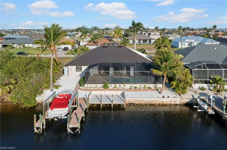 View of dock featuring a water view, boat lift, and a residential view