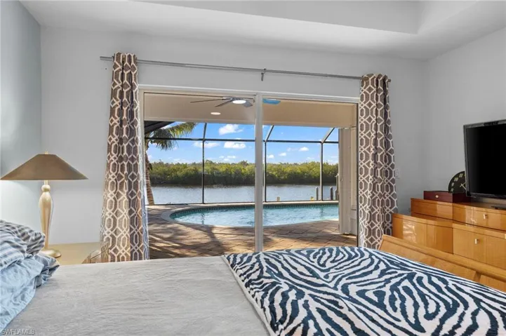 Bedroom with a sunroom, multiple windows, and access to exterior