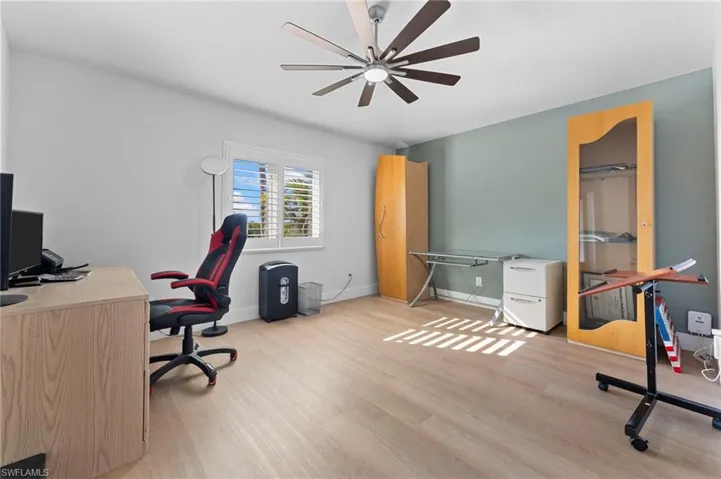 Office space with light wood finished floors, ceiling fan, and baseboards