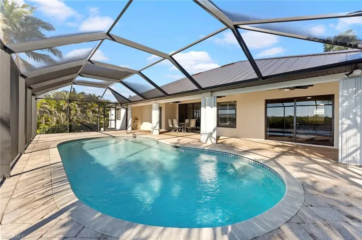 Pool with a ceiling fan, a lanai, and a patio area