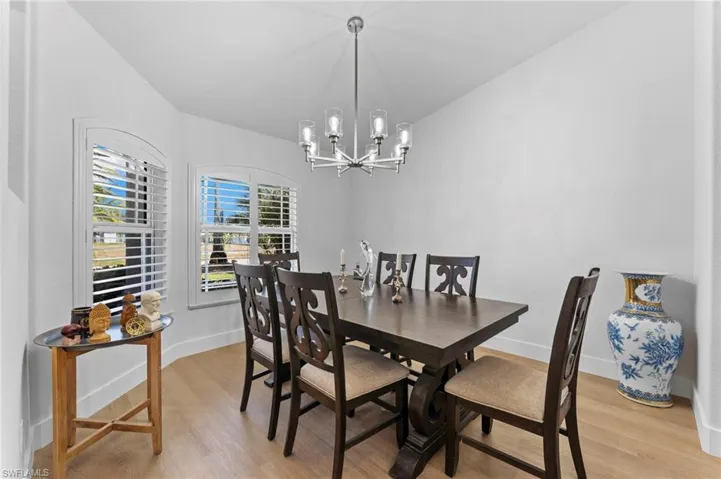 Dining room featuring baseboards, light wood-style flooring, and a notable chandelier