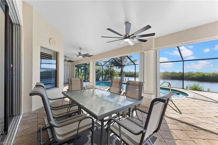 Sunroom / solarium featuring a water view, ceiling fan, and a pool