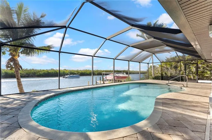Pool with a lanai, a water view, and a patio