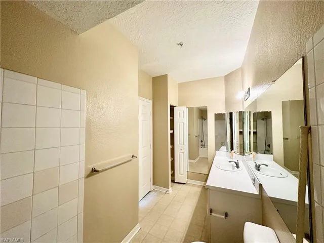 Bathroom featuring tile floors, a textured ceiling, and vanity