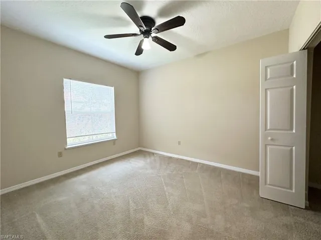 Unfurnished room with ceiling fan, a textured ceiling, and carpet flooring