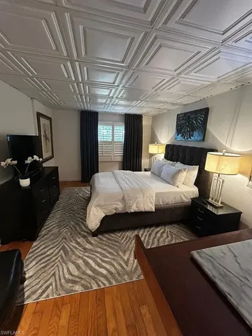 Bedroom featuring an ornate ceiling and wood finished floors