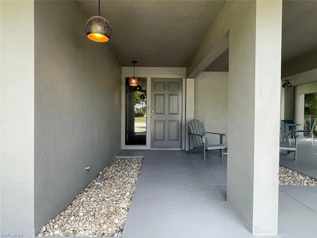 Entrance to property featuring stucco siding and a patio