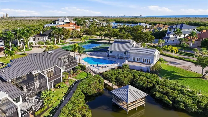 Aerial perspective of suburban area with a nearby body of water and a pool