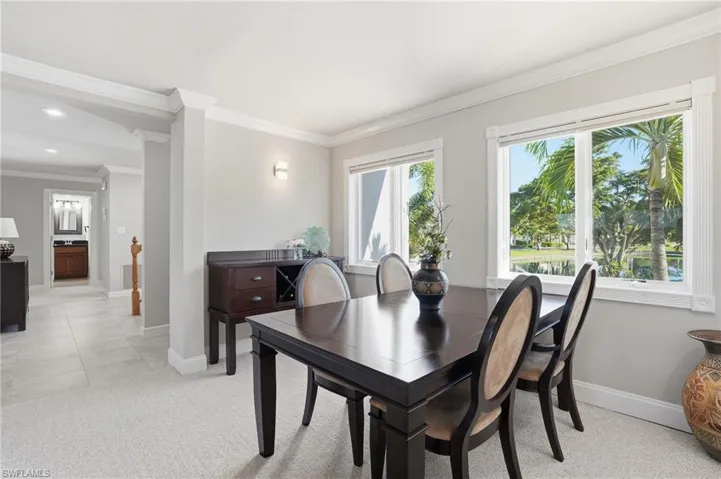 Dining space with light colored carpet and crown molding