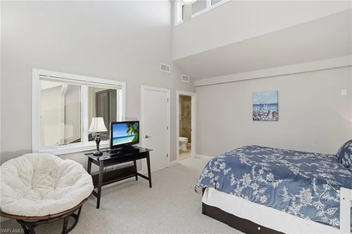 Bedroom featuring carpet flooring, a high ceiling, and ensuite bathroom