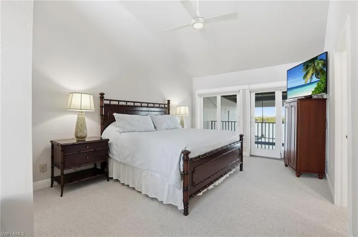 Bedroom featuring access to outside, high vaulted ceiling, light colored carpet, and a ceiling fan