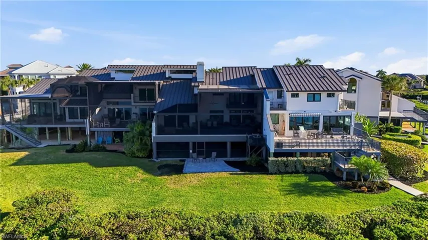 Back of house with a sunroom, a residential view, a metal roof, and a standing seam roof