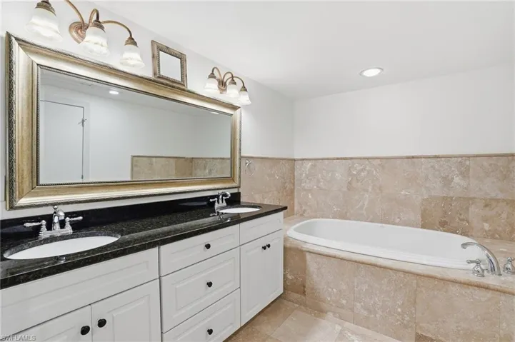 Full bath featuring double vanity, a garden tub, and recessed lighting