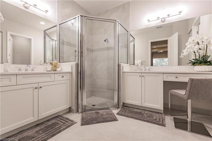 The master bath has upgraded tile inlay, custom mirrors, walk-in glass shower, and convenient nook for getting prepped for your night on the town-