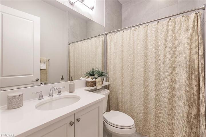 The guest bathroom has a tub/shower combination.  There is also tub to ceiling wall tile upgrades and custom mirror.
