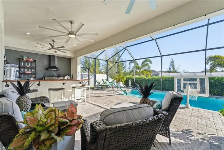 View of patio / terrace featuring a ceiling fan, a sunroom, a lanai, and an outdoor pool