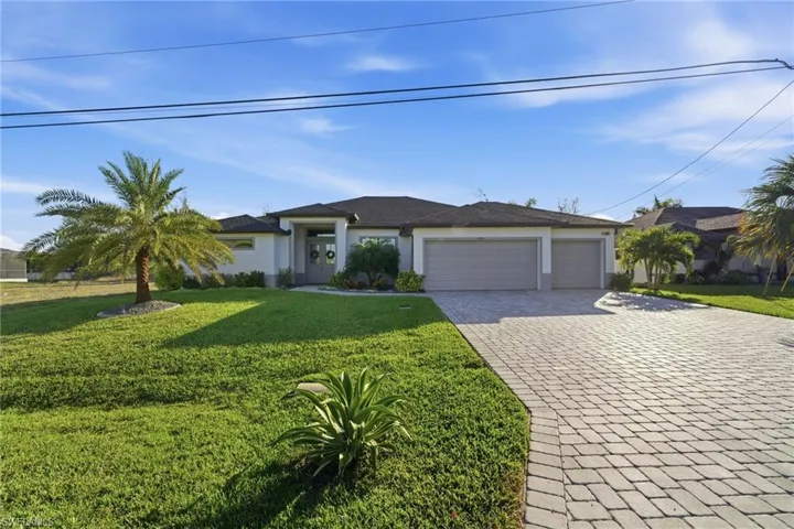 Single story home featuring a front yard, decorative driveway, a garage, and stucco siding