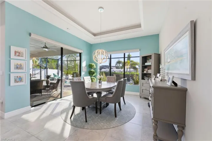 Dining area featuring a raised ceiling, plenty of natural light, ceiling fan, and a sunroom