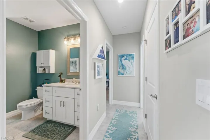Half bathroom with vanity and light tile patterned flooring