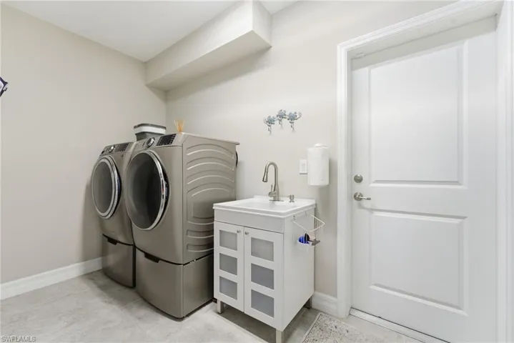 Washroom with baseboards and washing machine and clothes dryer
