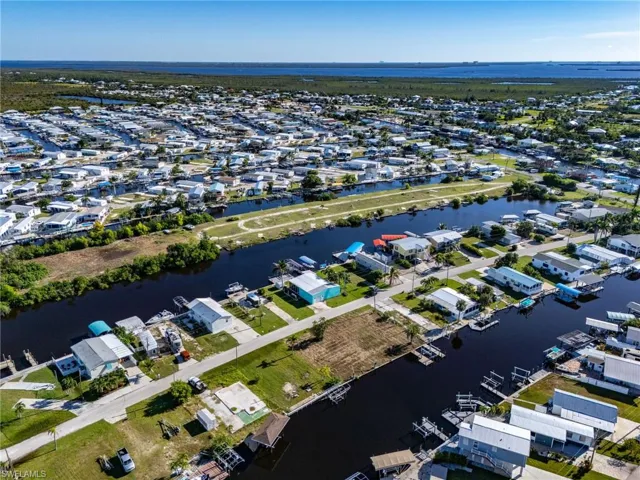 Aerial view of property's location with a large body of water and nearby suburban area