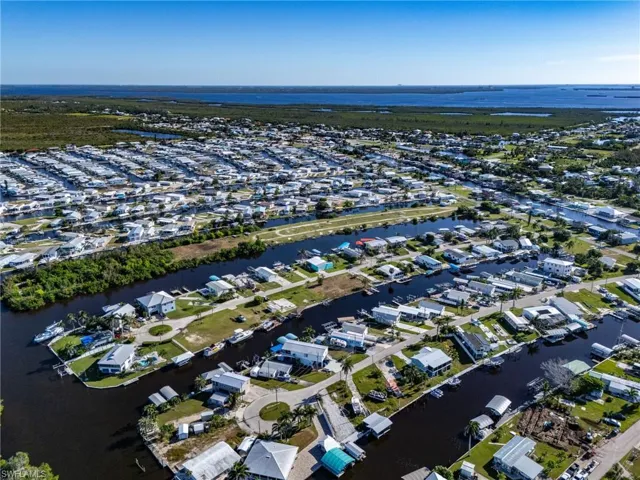 Aerial view of property's location featuring a nearby body of water and nearby suburban area