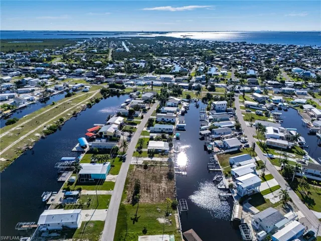 Aerial view of property and surrounding area with a nearby body of water and nearby suburban area