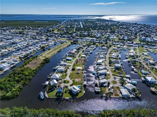 Aerial view of property's location with a large body of water and nearby suburban area