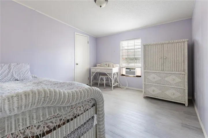 Bedroom with a textured ceiling and wood finished floors