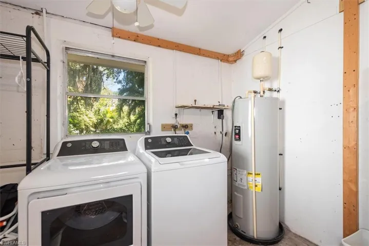 Laundry room featuring water heater and independent washer and dryer
