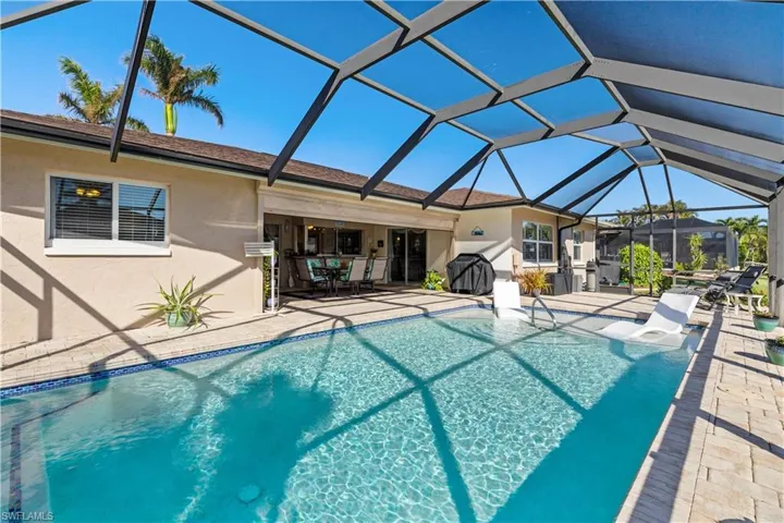 View of swimming pool featuring a patio area and glass enclosure
