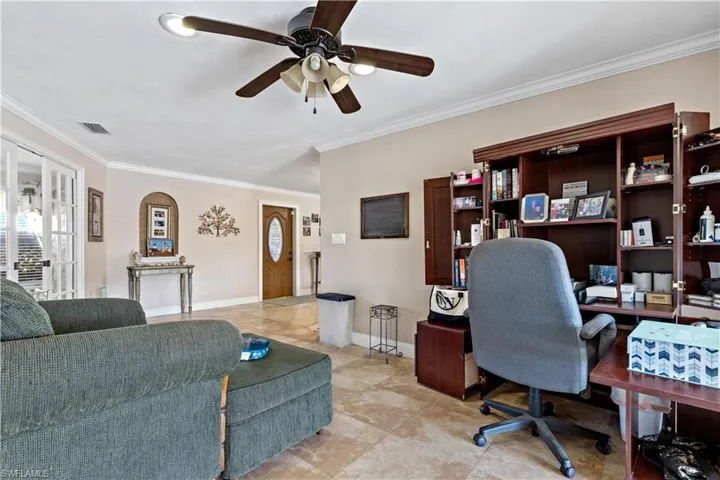 Office area with ceiling fan and crown molding