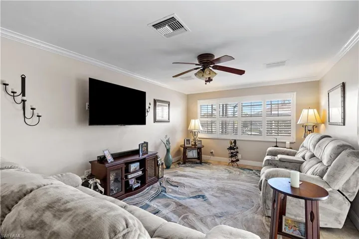 Living room featuring ornamental molding and ceiling fan