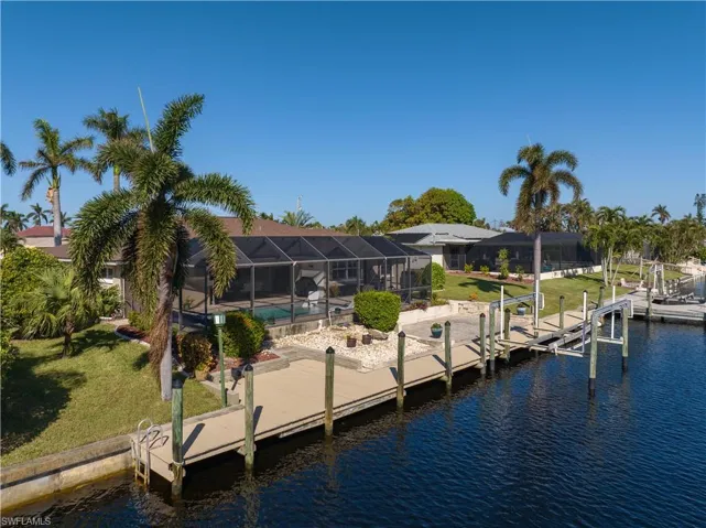 View of dock with a swimming pool, a yard, a water view, and glass enclosure