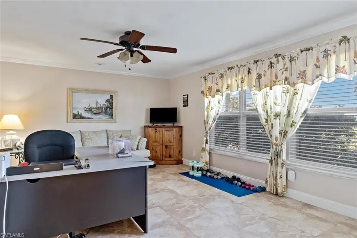 Office space with ornamental molding, light tile patterned flooring, and ceiling fan