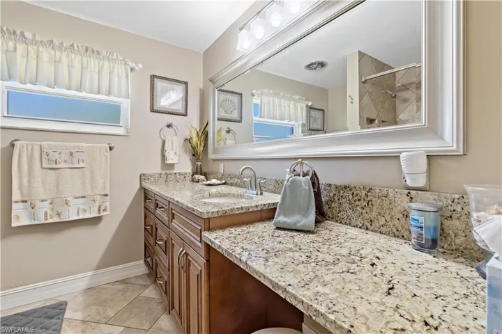 Bathroom featuring vanity, tile patterned floors, and tiled shower