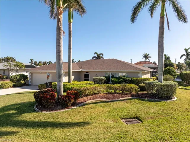 Ranch-style house with a front yard and a garage